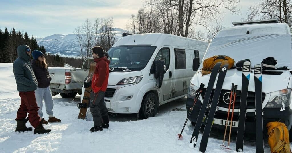 Ski tourers and Split boarders at their vanlife park up in the Lyngen Alps, Norway.