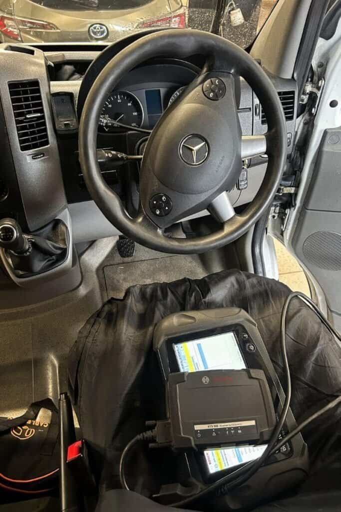 The inside of a Mercees Sprinter having a diagnostic test at the garage.