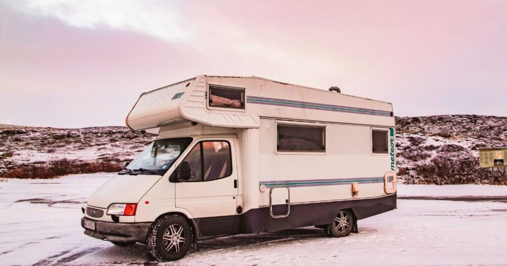 An old overcab motorhome parked in the snow 