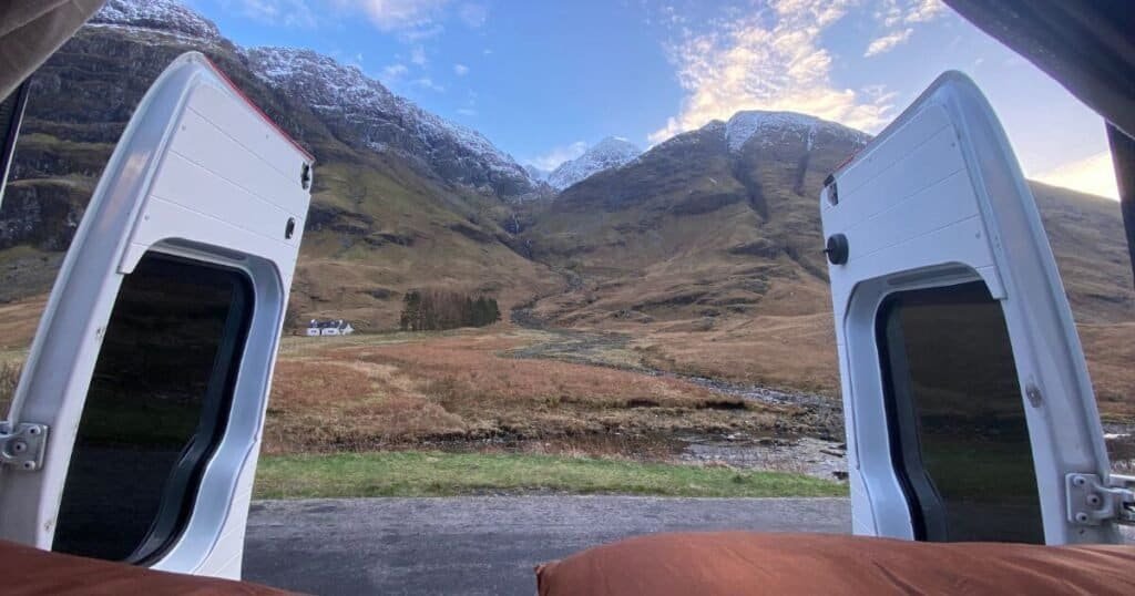 Views of the snow dusted, Autumn toned hills of Glencoe, from the back of a campervan bed.