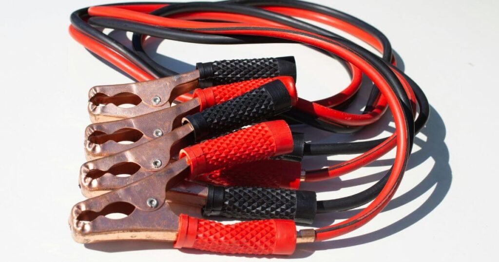 A close up picture of red and black vehicle jumper cables on a white background 