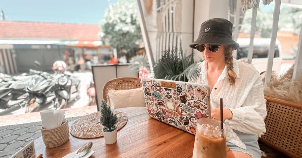 Woman and her laptop sat outside at a cafe in Thailand.