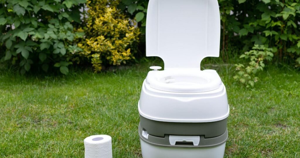 A Porta Potti Toilet for Van life: sat outside on grass with toilet roll next to it. 