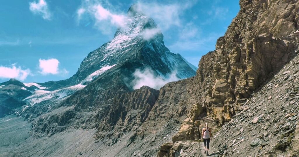 Woman walking to to Hörnlihütte, known as the base camp for the Matterhorn.